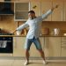 Handsome young funny man dancing in kitchen at home in the morning and have fun on vacation